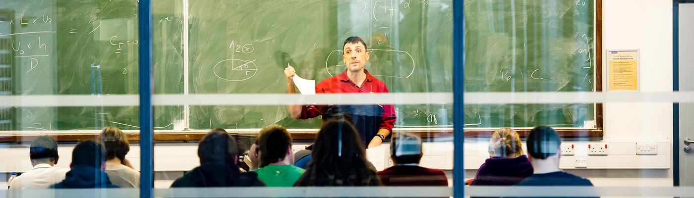 Professor teaching class of students in seminar room
