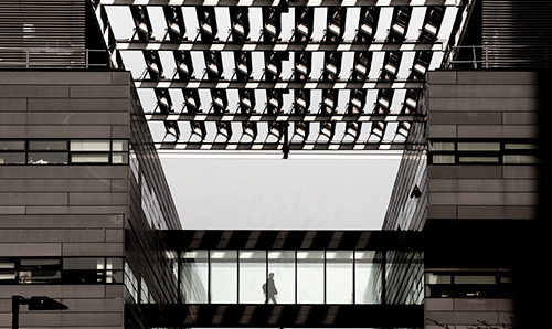 Student walking across walkway in Alan Turing Building