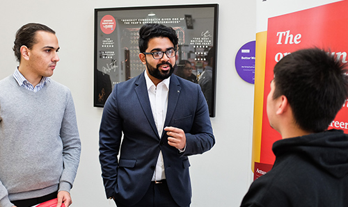 Prospective employer in discussion with student at careers event