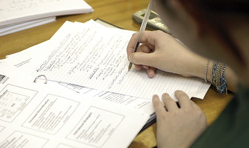 Researcher working on paper on a desk