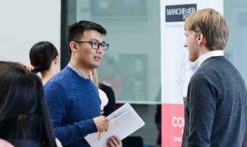Two men in deep discussion at a University event