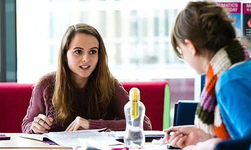 Two female students discussing their work