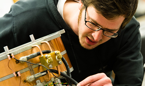 A male maths researcher operating industrial equipment