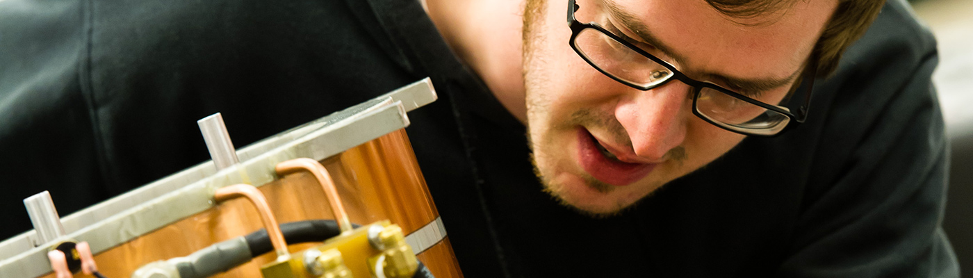 A male maths researcher operating industrial equipment